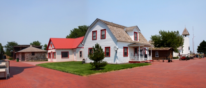 [Stitched two photos together showing five buildings as seen from the corner of a street.]